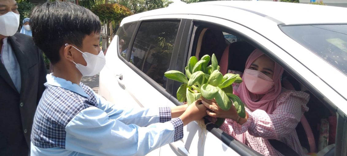 Siswa SD Muhammadiyah 2 GKB saat membagikan sayuran ke warga sekitar