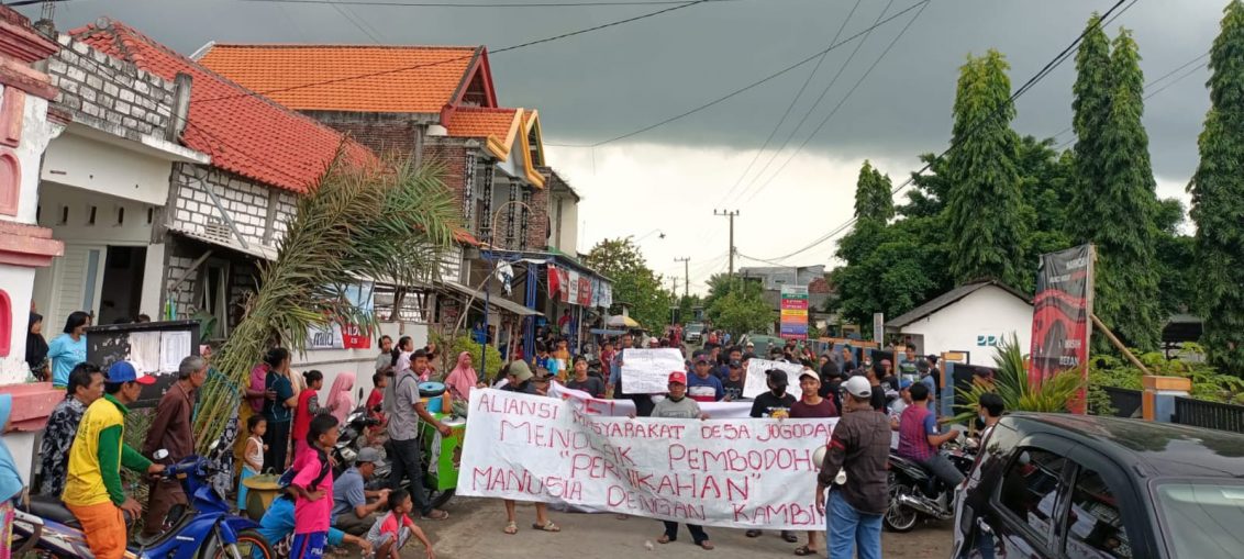 Aliansi Masyarakat Desa Jogodalu akhirnya turun jalan menggelar demonstrasi di Pesanggrahan Keramat Ki Ageng, yang merupakan Tempat Kejadian Perkara (TKP) prosesi nyeleneh manusia menikah dengan seekor kambing, Senin (13/6/2022).
